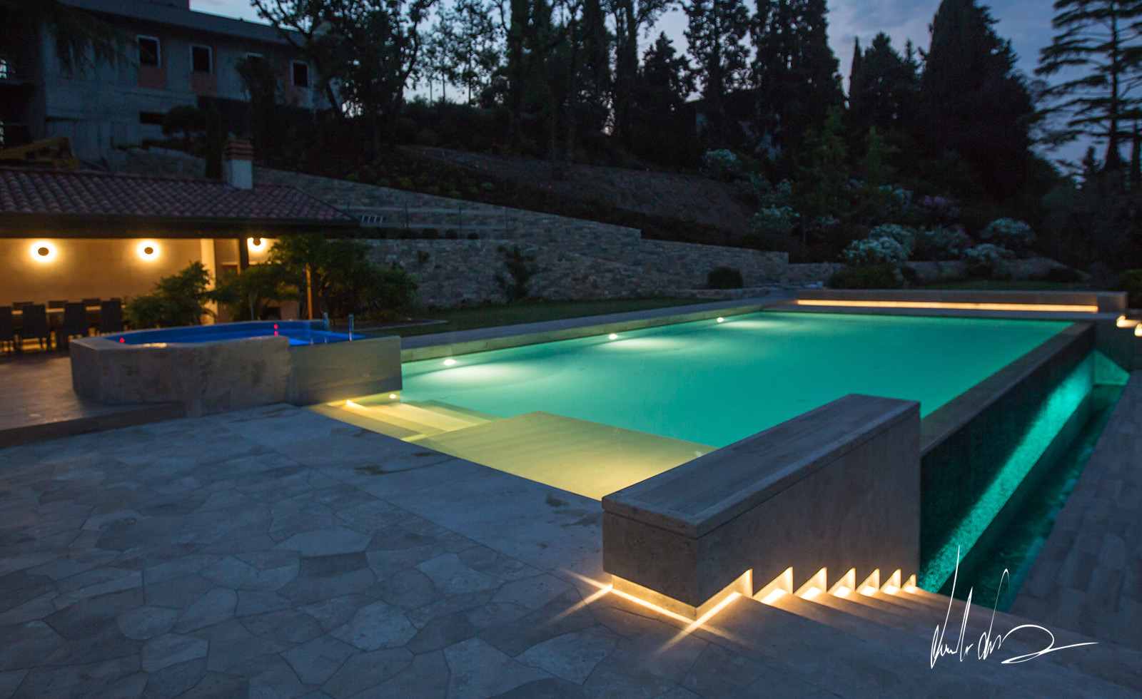 Piscina e vasca idromassaggio in travertino al tramonto