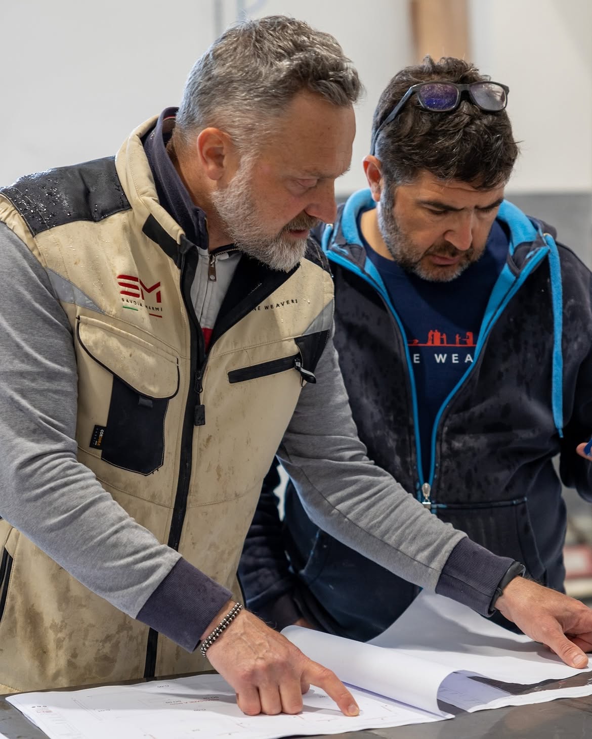 Due tecnici Savoia Marmi sui disegni di un progetto in officina